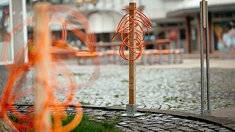 Work of art made of orange charging cables from Coroflex