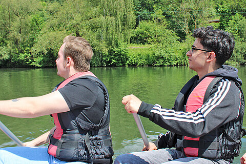 Zwei Azubis beim Rudern des Rafting-Boots