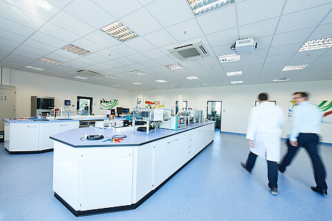 Zwei Mitarbeiter gehen durch das Prüflabor