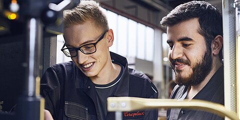 Zwei junge Mitarbeiter bei der Kabelproduktion